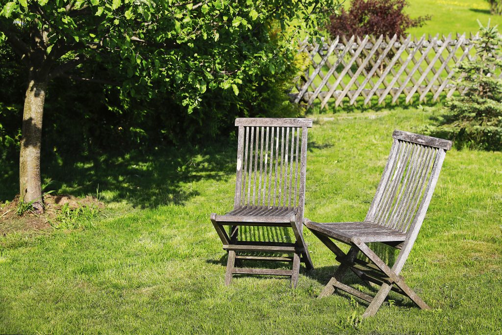 Zwei Holzstühle auf der Wiese im Garten